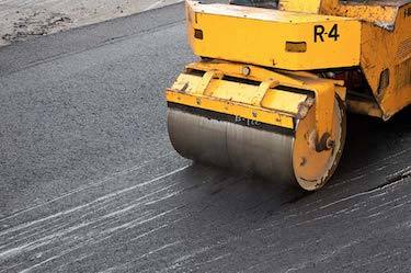 Asphalt roller compacting new asphalt road