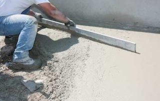 Construction worker installs fresh concrete