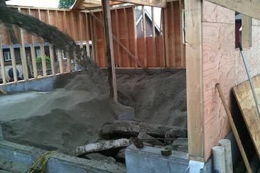 Custom builders pour material into basement foundation