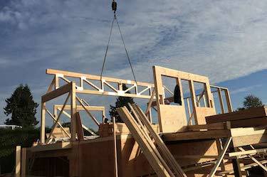 Crane lowers support beams for custom build