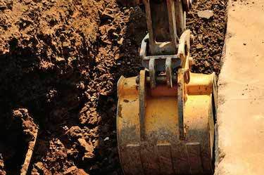 Excavator digs large trench