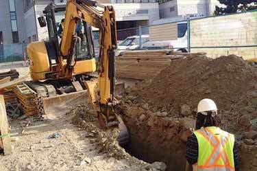 Excavator digs large drainage trench