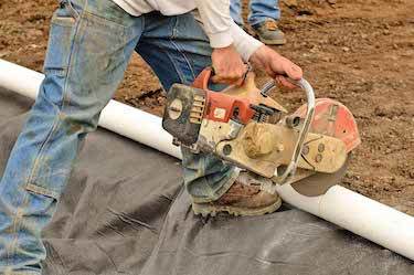 Drainage expert saws through drainage pipe