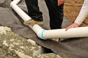 Two drainage experts assemble drainage pipes