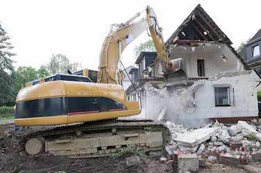 Excavator demolishes old home