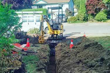 Mini excavator digging trench