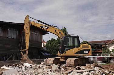 Excavator moves rubble after demolition