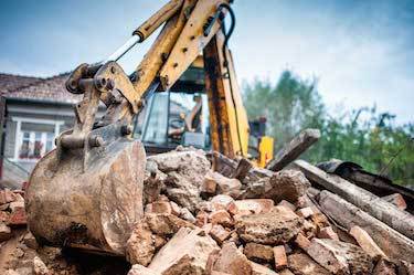 Excavator moves cement rubble