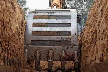 Excavator digs large trench