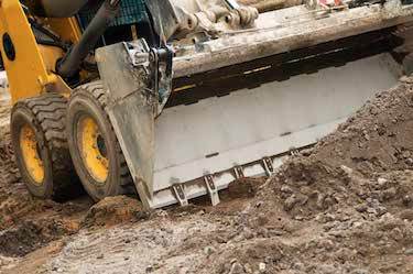 bobcat pushing dirt on construction site