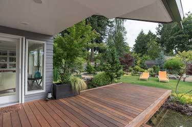 Raised wooden deck in beautiful green backyard