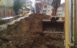 Excavator digs trench to prepare for drainage installation