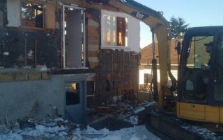 Excavator demolishes old house