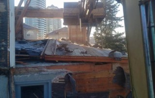 Excavator demolishes the top floor of an old house