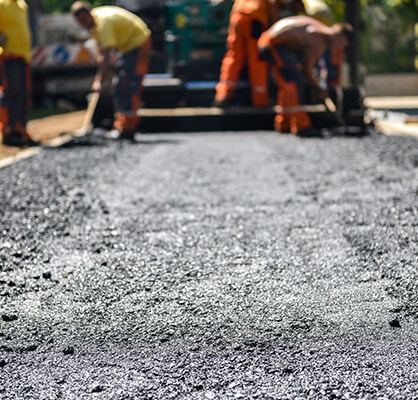 Asphalt contractors lay new asphalt road